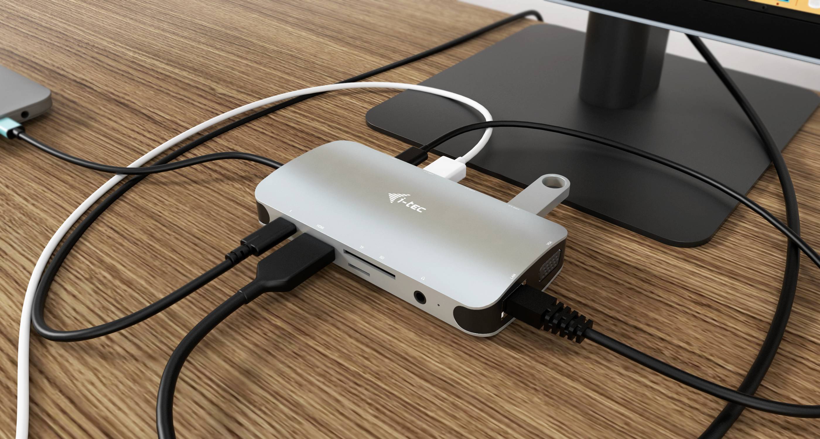 Un hub USB-C sur un bureau, connecté à plusieurs câbles et appareils, y compris un moniteur et une clé USB.