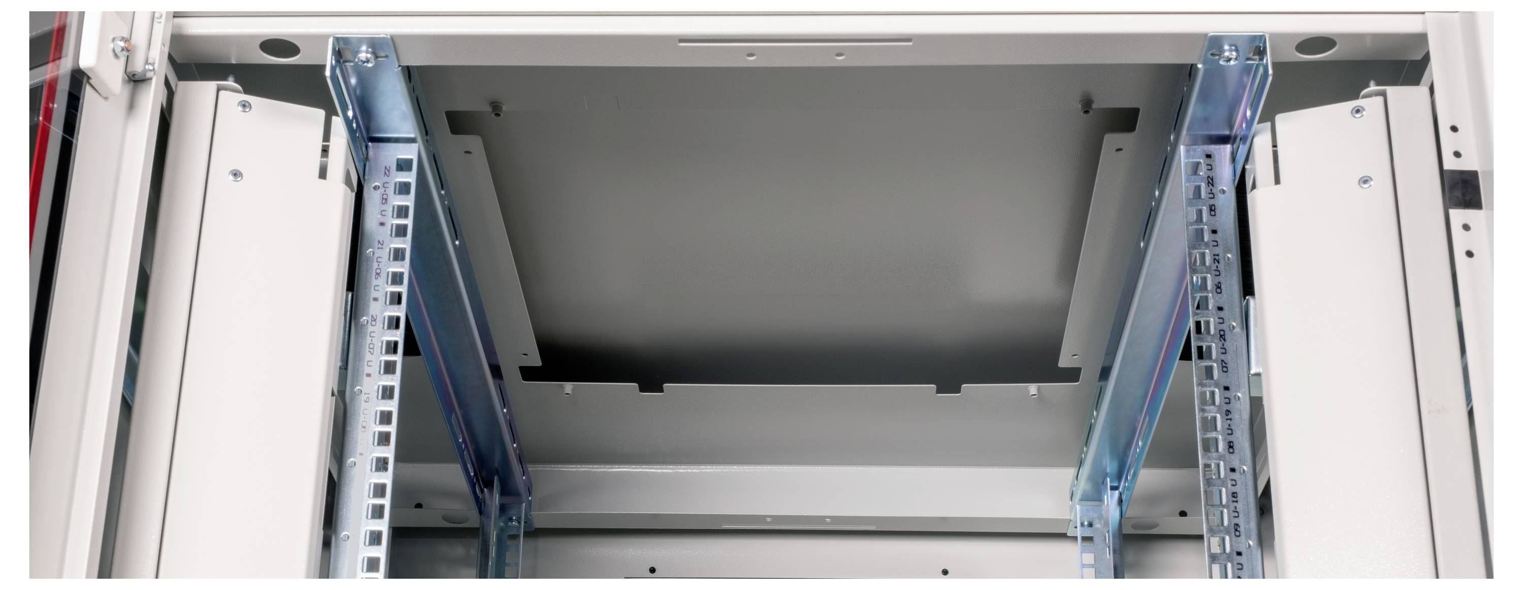Un regard ouvert à l'intérieur d'un coffret électrique, avec des profilés et des rails de montage bleus et blancs visibles.