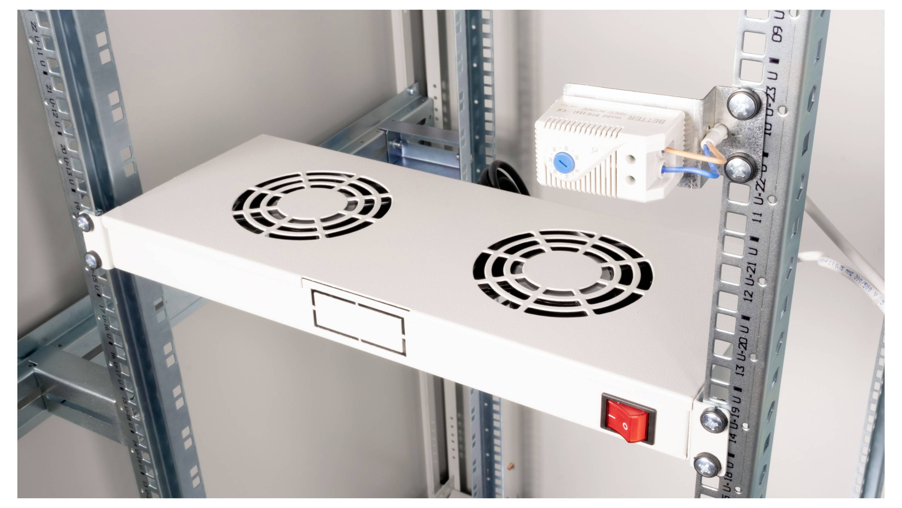 Un ventilateur doté de deux hélices et d'un interrupteur rouge, monté sur un châssis métallique, destiné au refroidissement d'appareils électroniques.