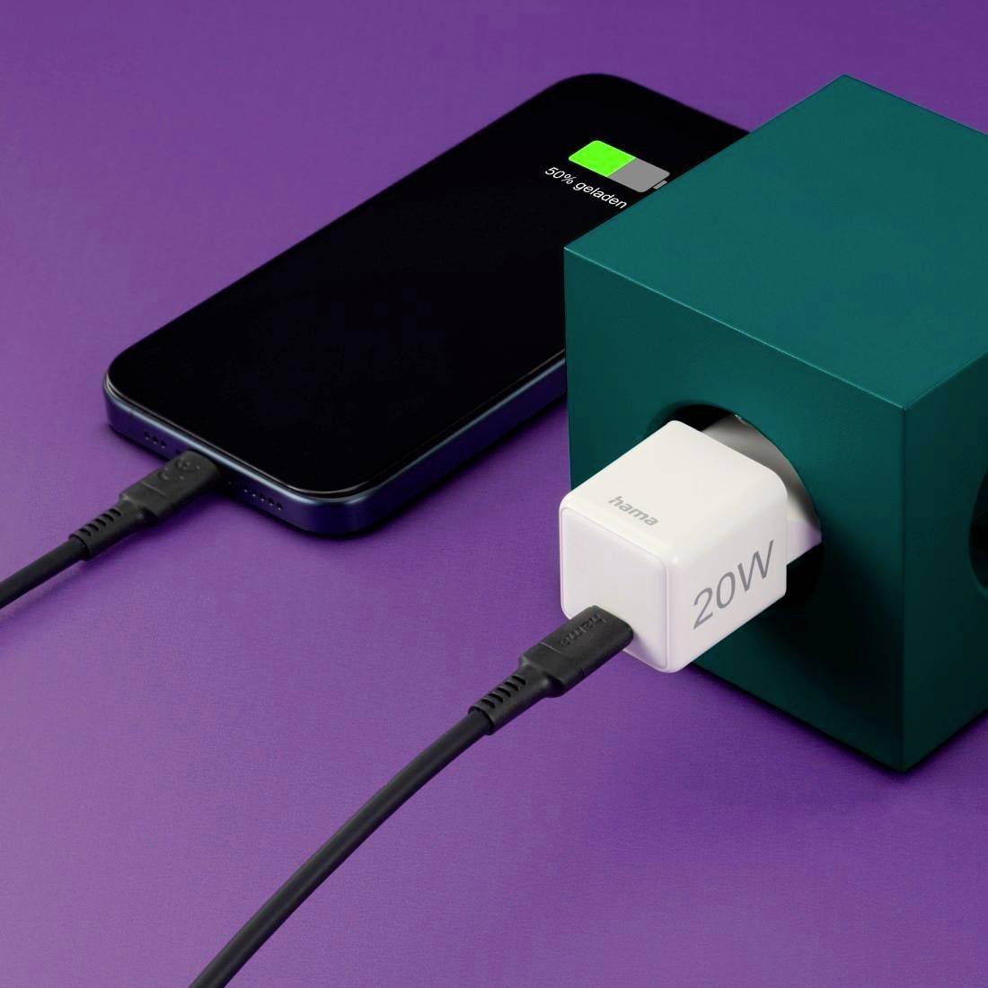 Un smartphone est en cours de chargement avec un câble de 20W connecté à un chargeur cube. La batterie est presque pleine.