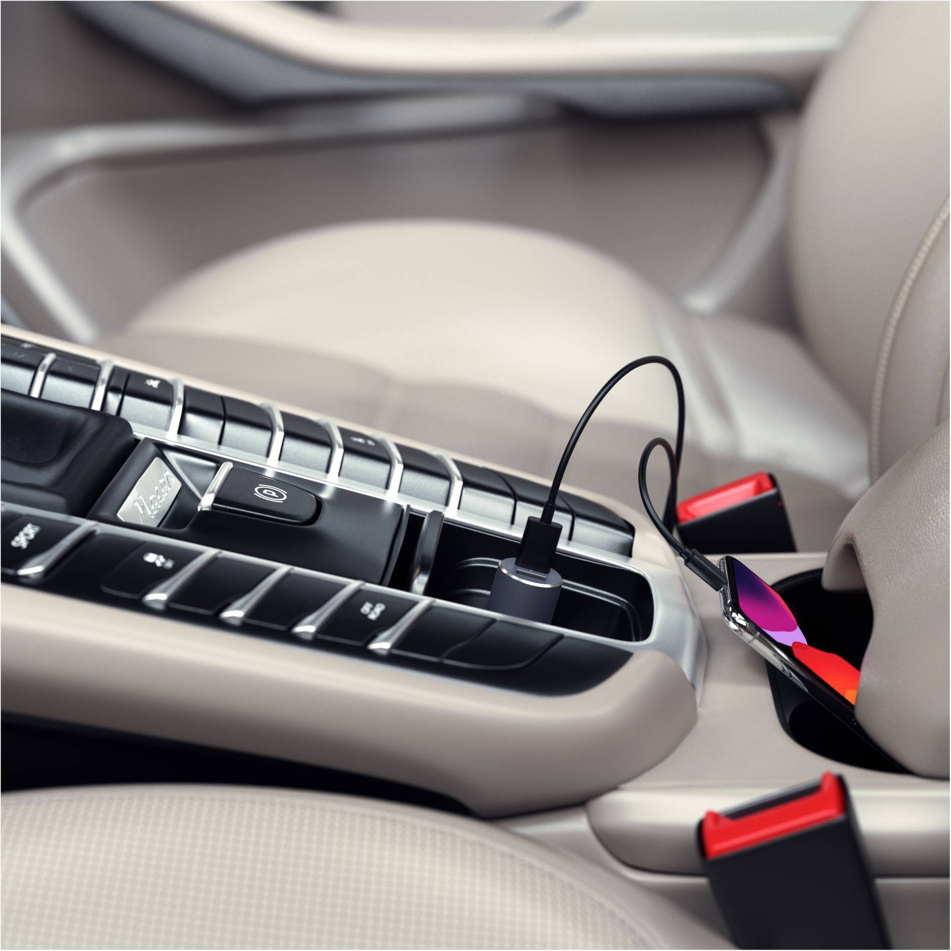 Un smartphone est en train d'être chargé dans une voiture. Il est posé dans la console centrale et branché à la prise de chargement par un câble.