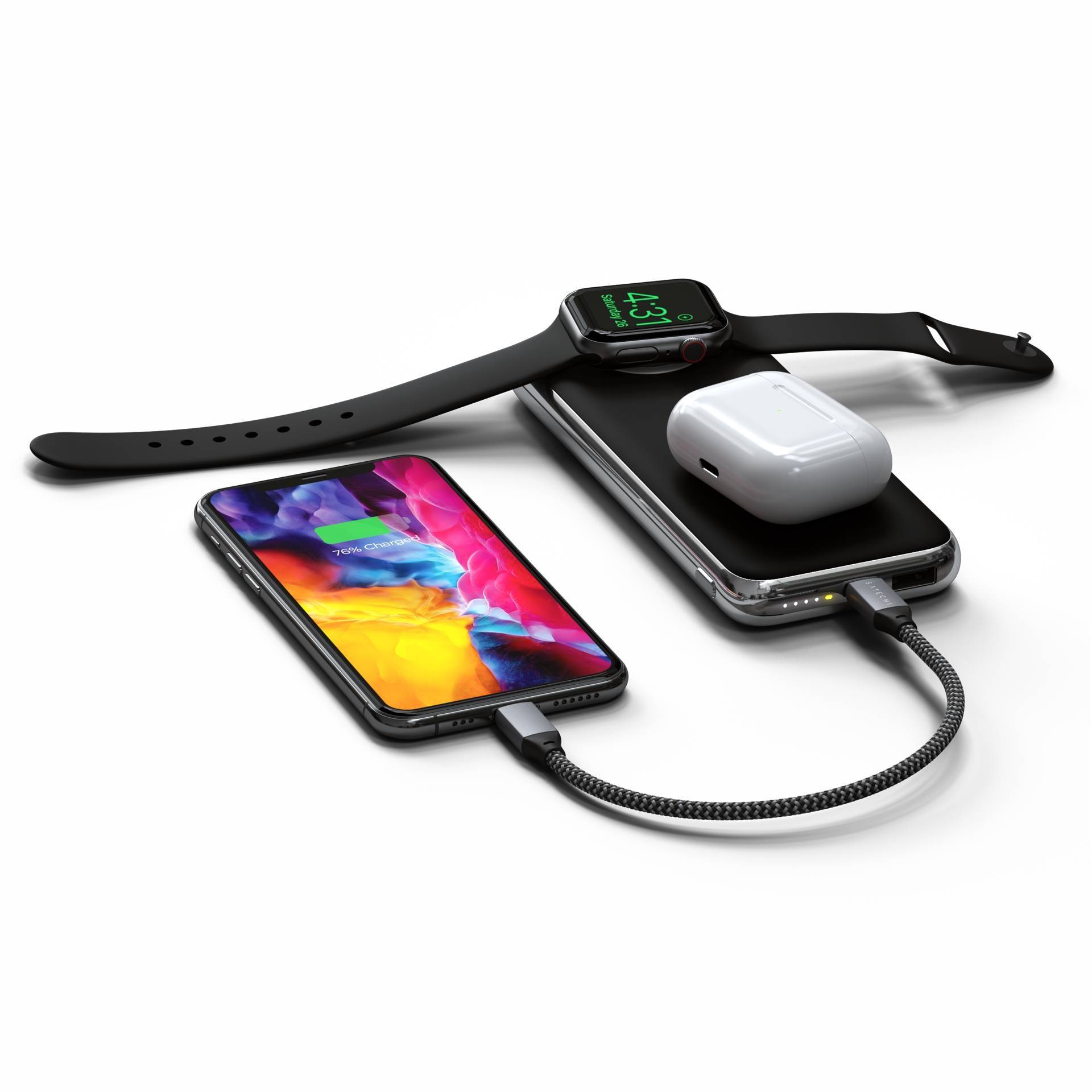 Tablette, smartphone, montre connectée et écouteurs sans fil sont posés sur une station de charge. Tous les appareils sont en train de charger simultanément.