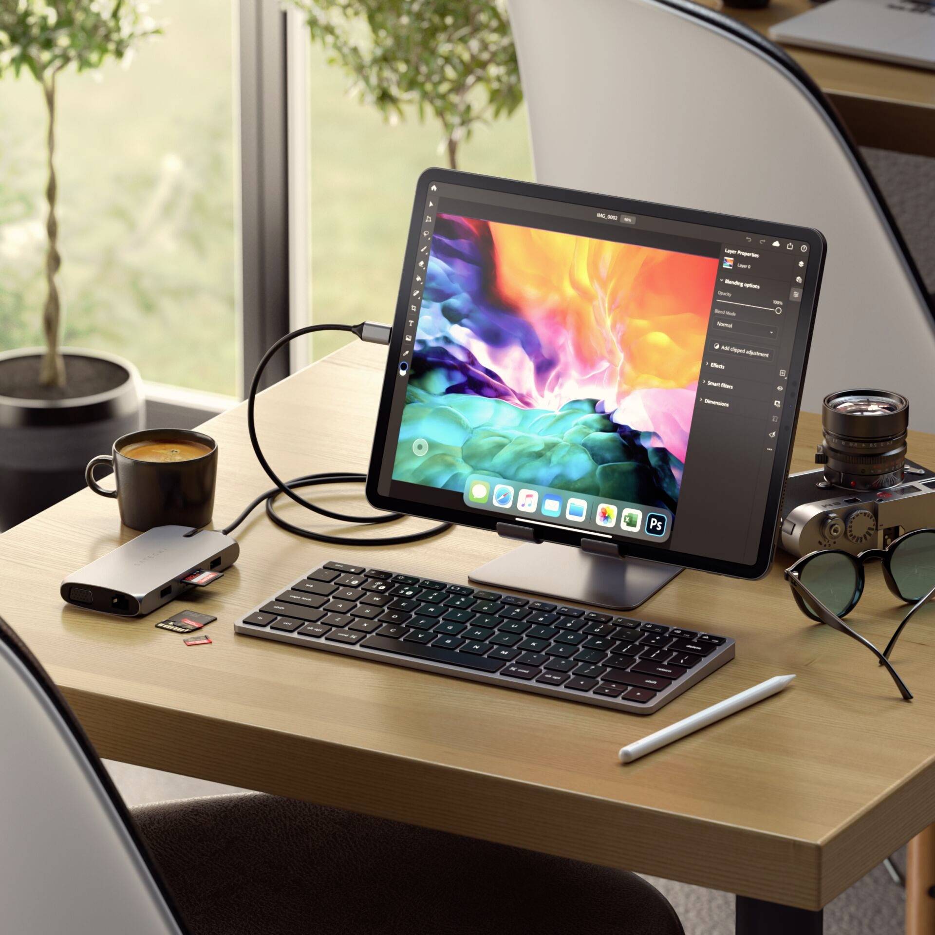 Tablette avec un graphique coloré sur un bureau, connectée à un clavier et une souris. À côté d'une tasse de café et de plantes en arrière-plan.