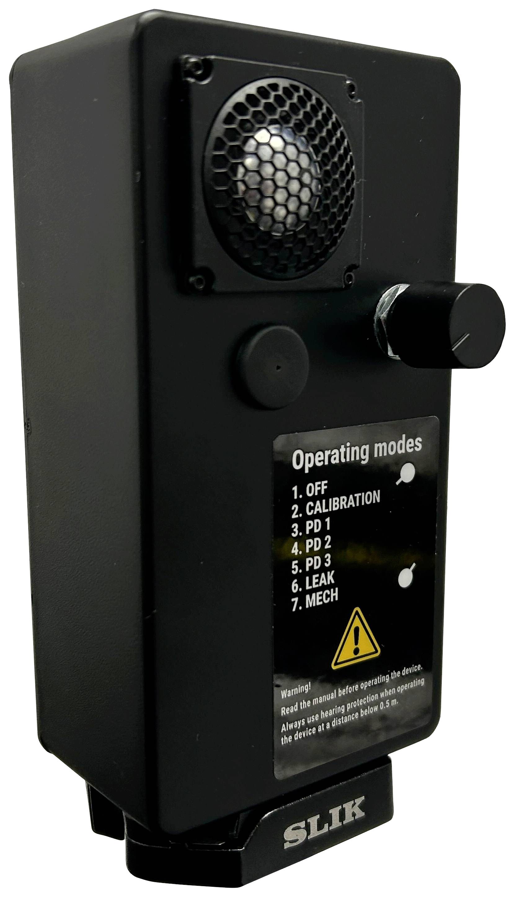 Appareil électronique noir avec haut-parleur et bouton rotatif. L'étiquette indique des modes de fonctionnement tels que 'OFF', 'CALIBRATION' et 'LEAK'.