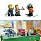 Trois figurines Lego en uniforme de police et de pompiers sont debout à côté d'une table de bricolage. Sur la table, un hélicoptère jouet, un camion de pompiers et d'autres figurines.