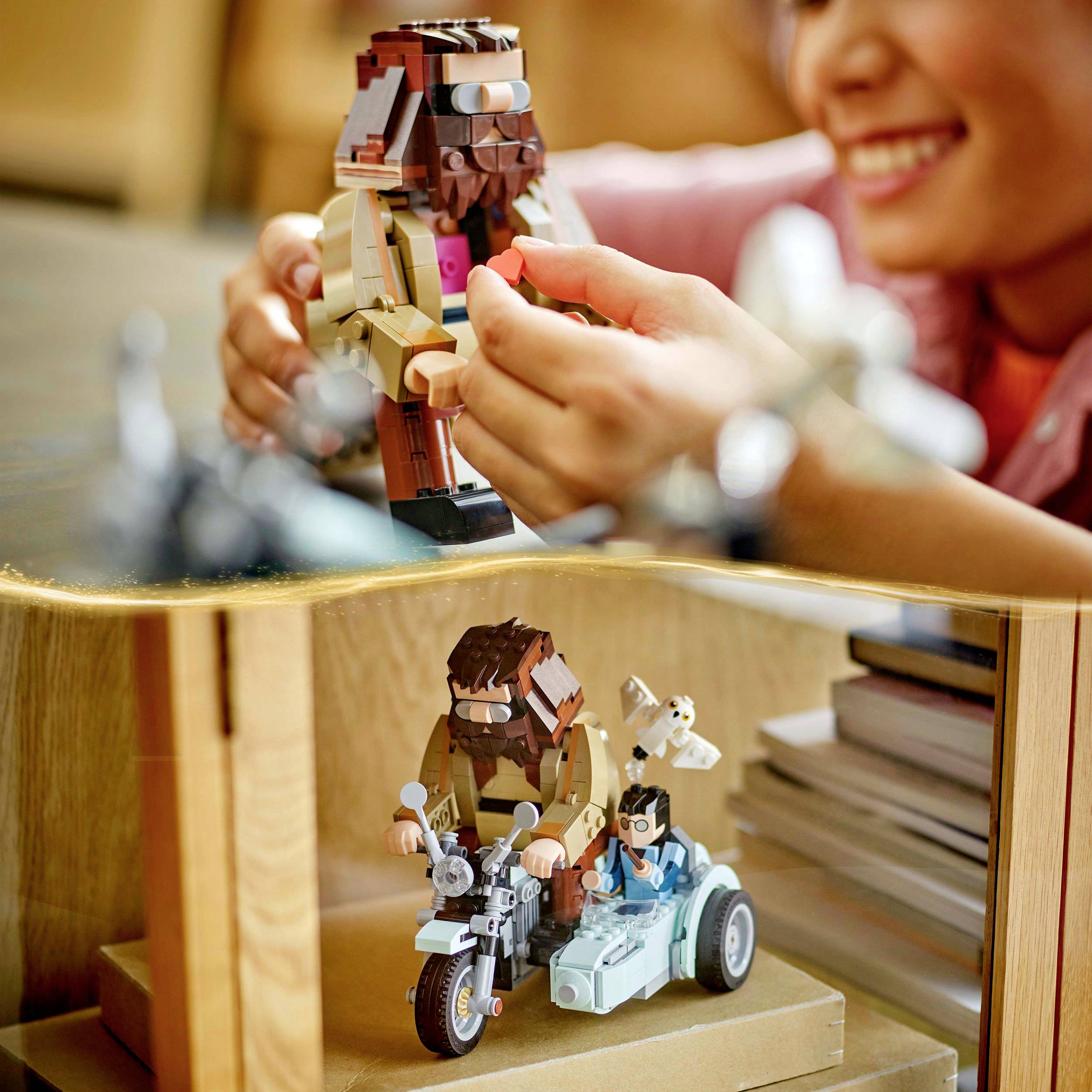 Un enfant joue avec des figurines Lego sur une table. Les figurines sont détaillées et colorées, dont une moto avec deux personnages.