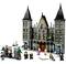 Ensemble LEGO d'une façade de château avec plusieurs minifigures devant, dont des personnages avec des baguettes magiques et des créatures fantastiques.