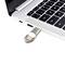 Une clé USB métallique est branchée dans un ordinateur portable, l'ordinateur portable a un clavier noir et est partiellement visible.