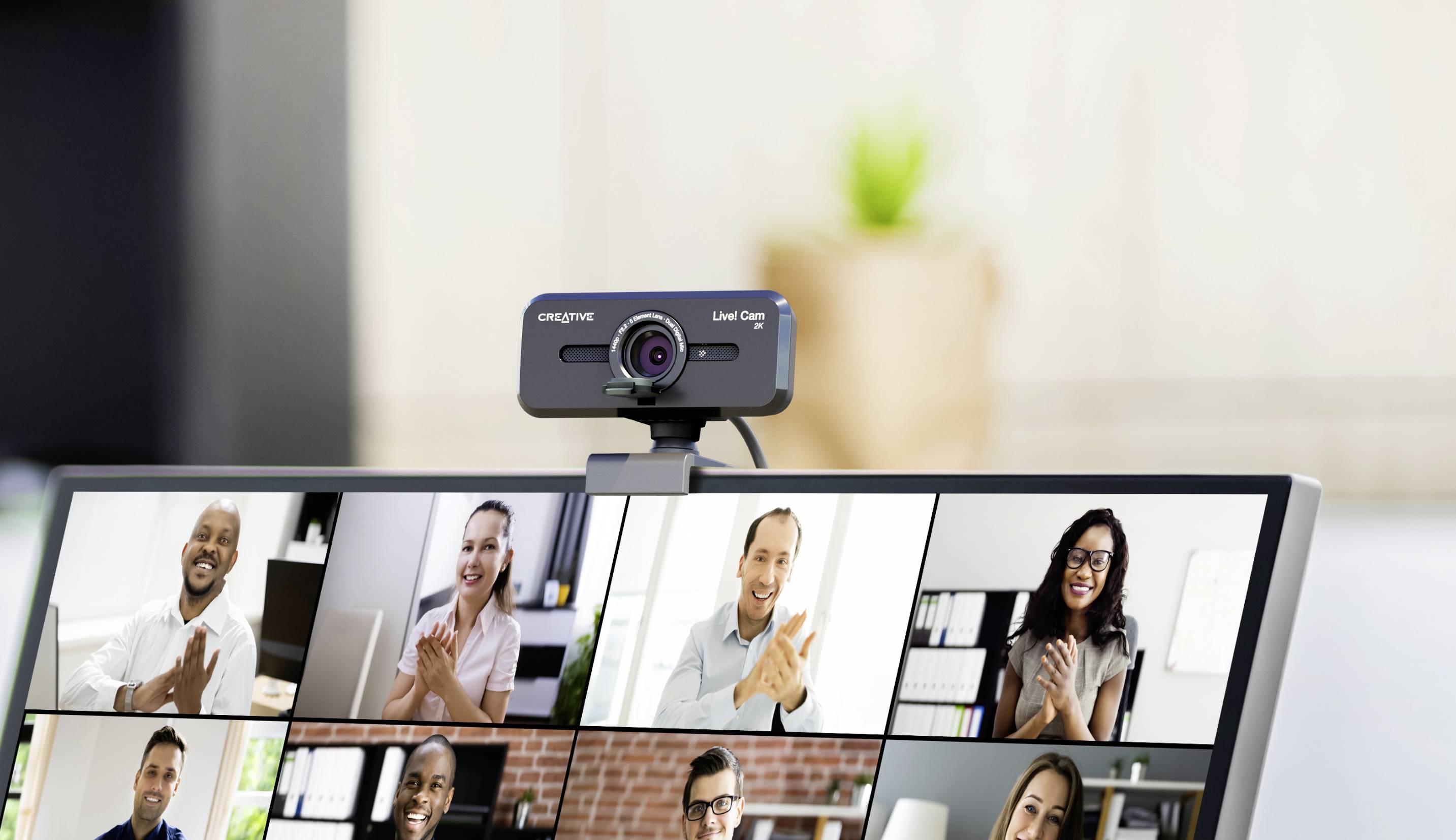 Plusieurs personnes lors d'une réunion par visioconférence sur un écran d'ordinateur, tous sourient et applaudissent devant leurs webcams.
