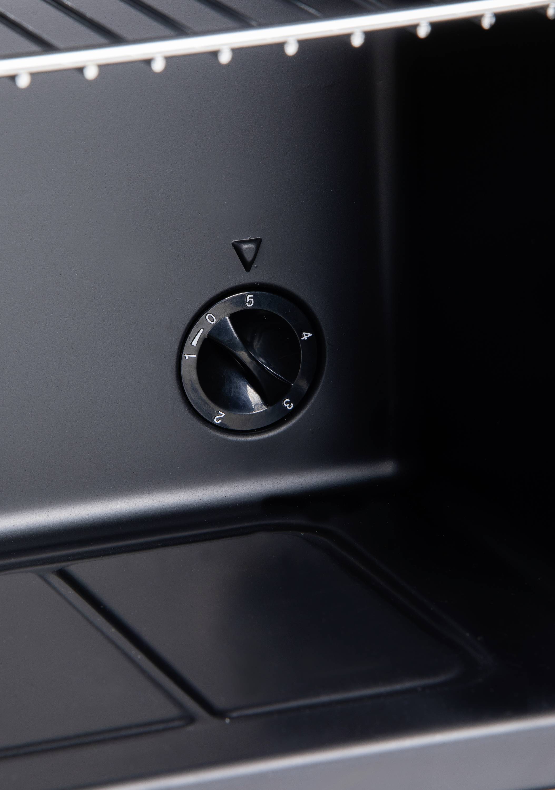 Un panneau de commande noir avec un bouton rotatif numéroté de 0 à 5. Le bouton est positionné sur le chiffre 5.