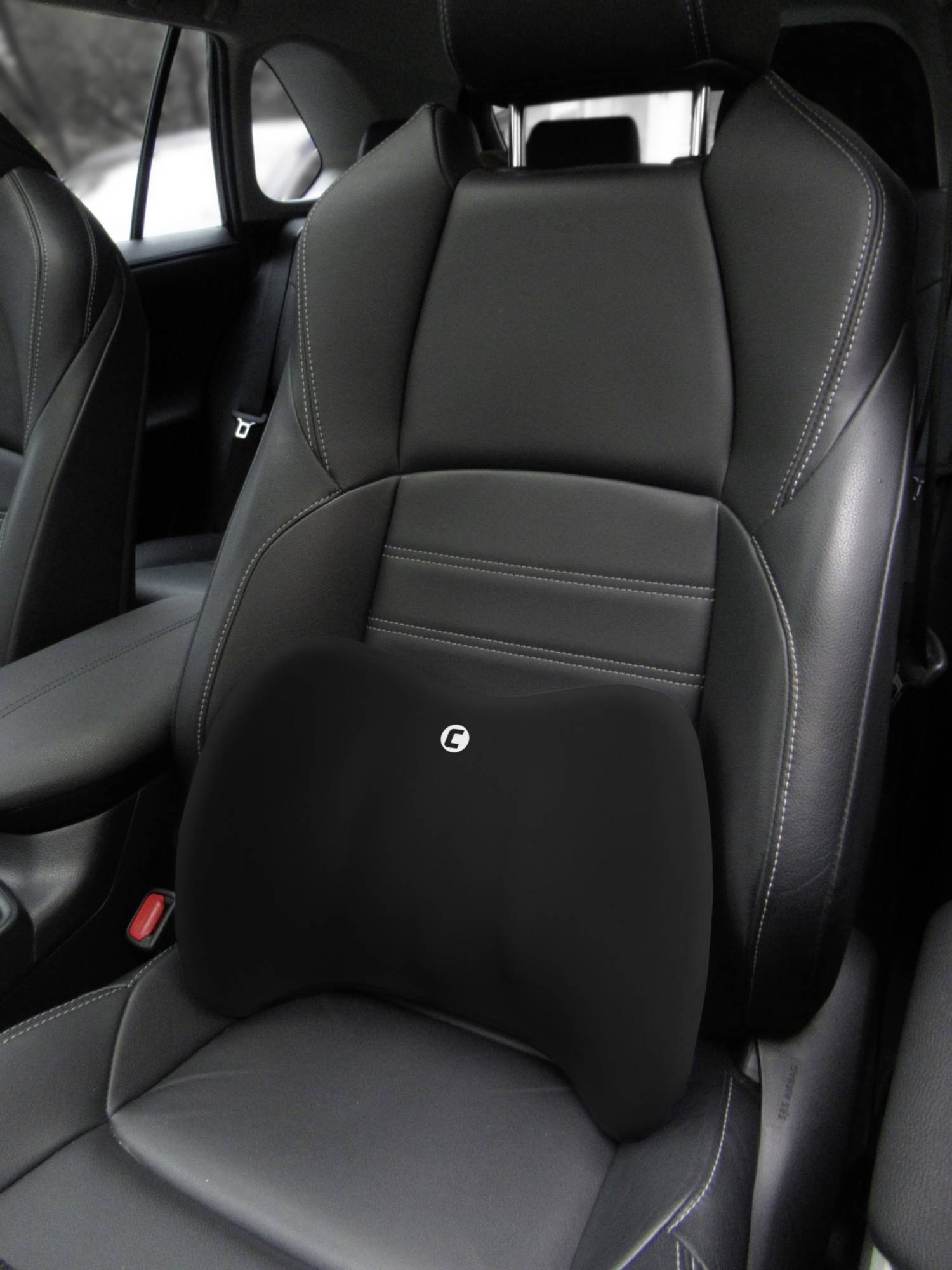 Un siège de voiture recouvert de cuir sombre avec un support lombaire noir supplémentaire, conçu pour soutenir le bas du dos.