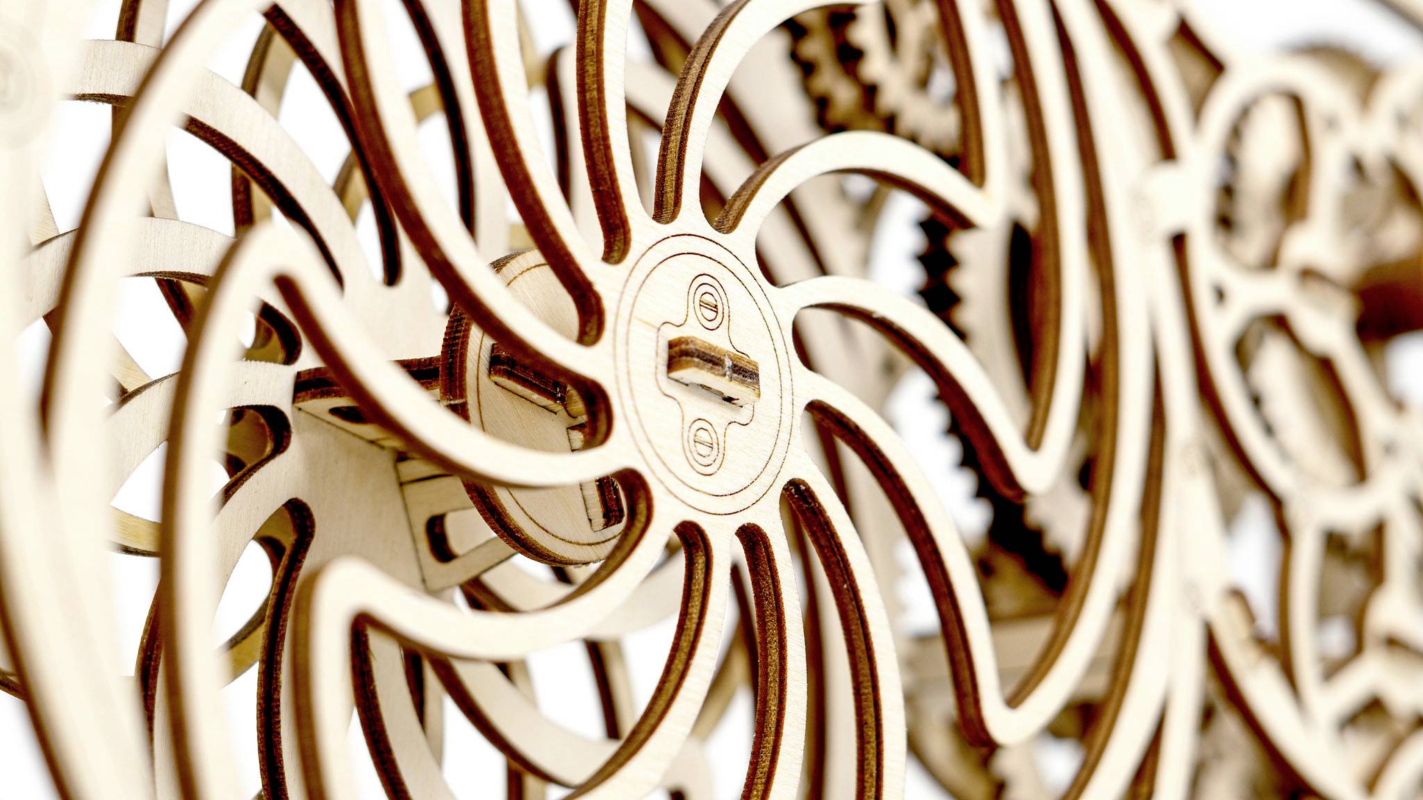 Engrenages en bois avec des roues dentées et des motifs délicats qui s'imbriquent. Les détails mécaniques sont visibles.