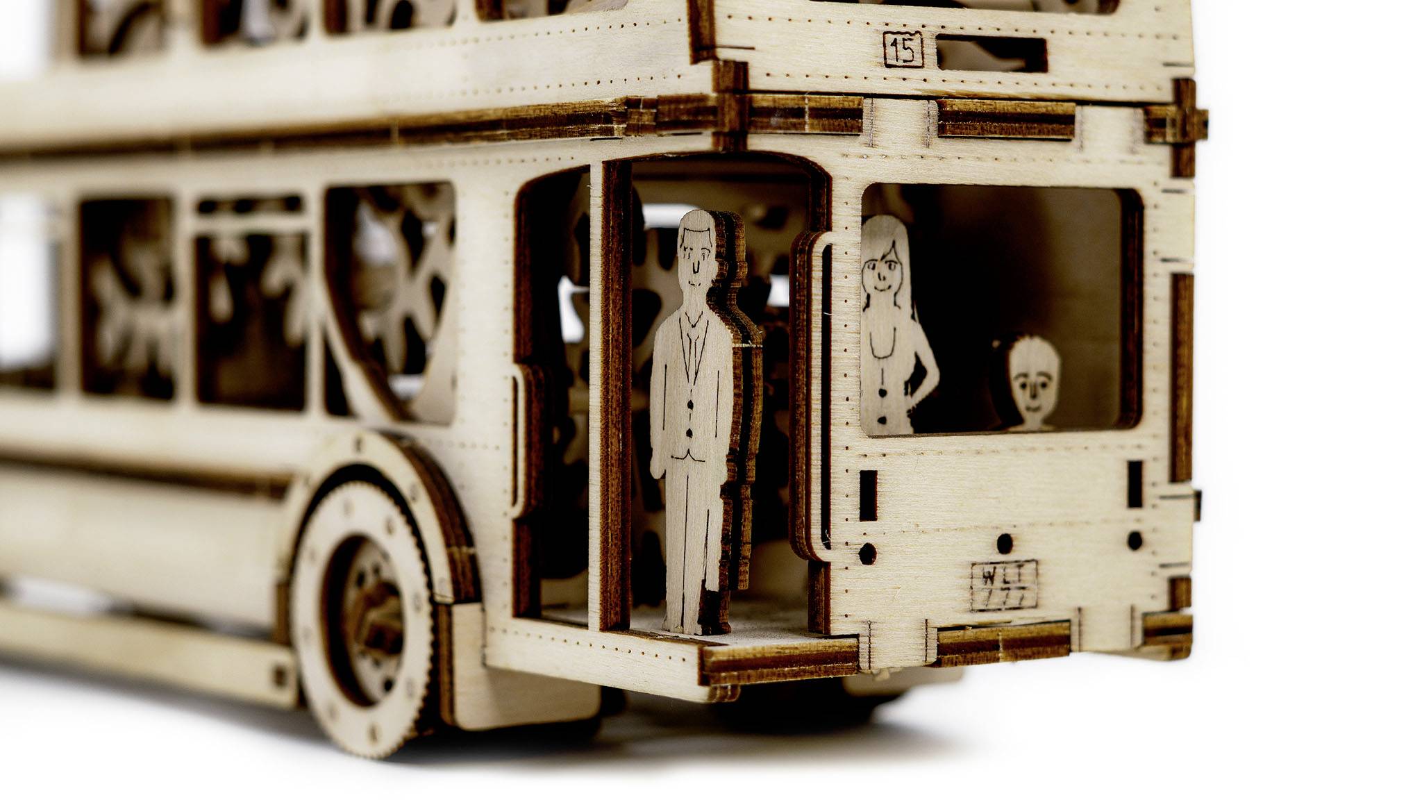 Modèle en bois d'un bus à impériale avec des détails découpés. Trois personnages sont à l'intérieur.