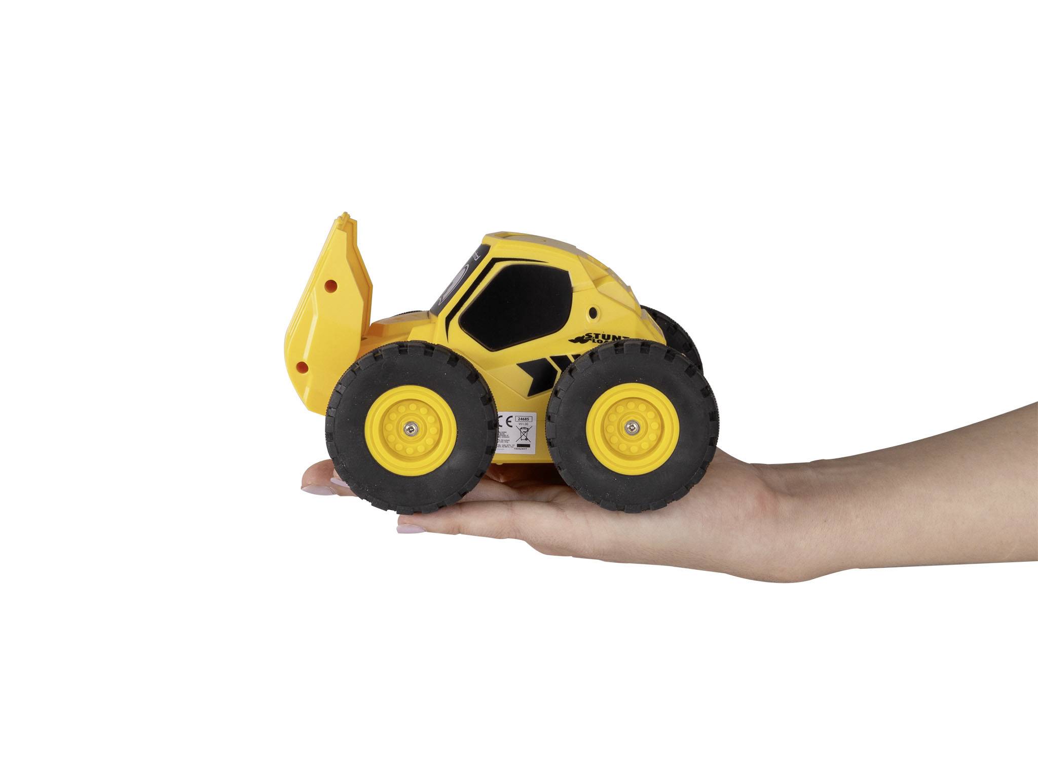 Un petit modèle de pelleteuse jouet jaune avec des roues noires est tenu dans une main.