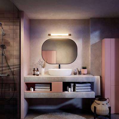 Une salle de bain moderne avec des accents roses, un miroir rétroéclairé, un lavabo avec des produits de soin et un espace douche.