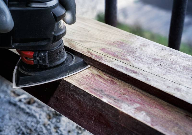 Une machine à poncer traite une pièce de bois allongée afin de lisser sa surface.
