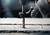 Gros plan d'une personne perçant du béton avec un marteau-piqueur, main gantée. Focus sur l'embout de forage.