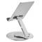 Un support de tablette en métal argenté, réglable, avec une base ronde et un bras pivotant permettant différents angles de vue.