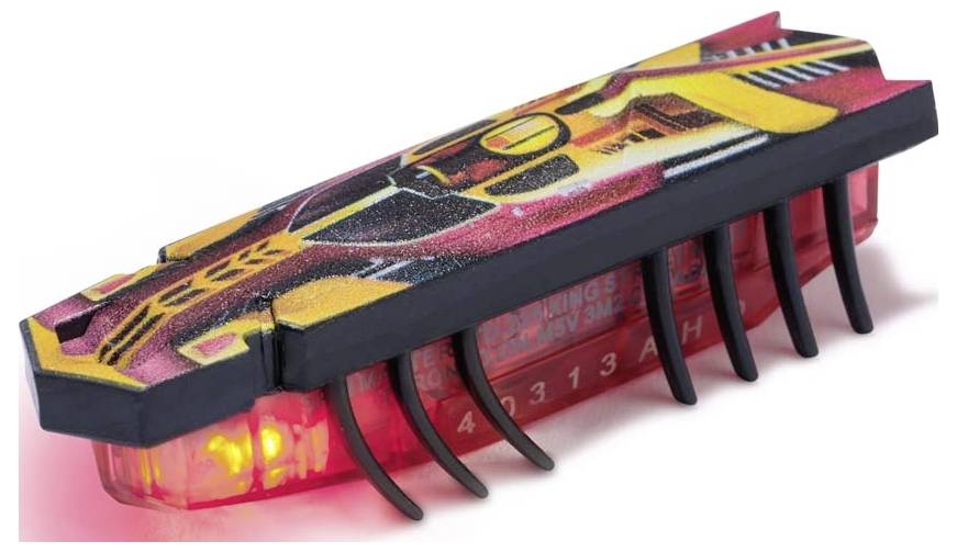 Un petit insecte jouet alimenté par batterie avec un design néon, debout sur une surface.