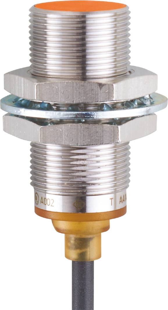 Gros plan d'une fiche métallique avec un écrou hexagonal et un boîtier nervuré, probablement un connecteur électrique.