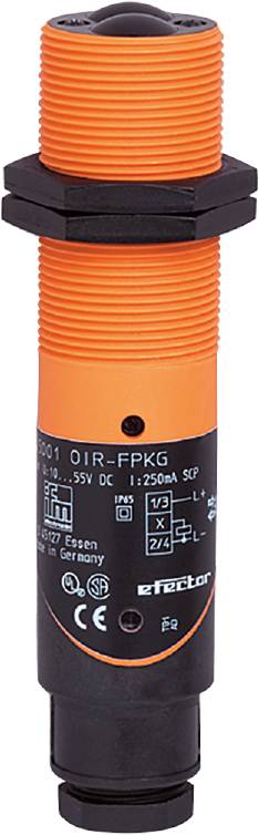Un capteur cylindrique avec un boîtier orange et une base noire sur laquelle sont imprimées des spécifications techniques et des symboles.