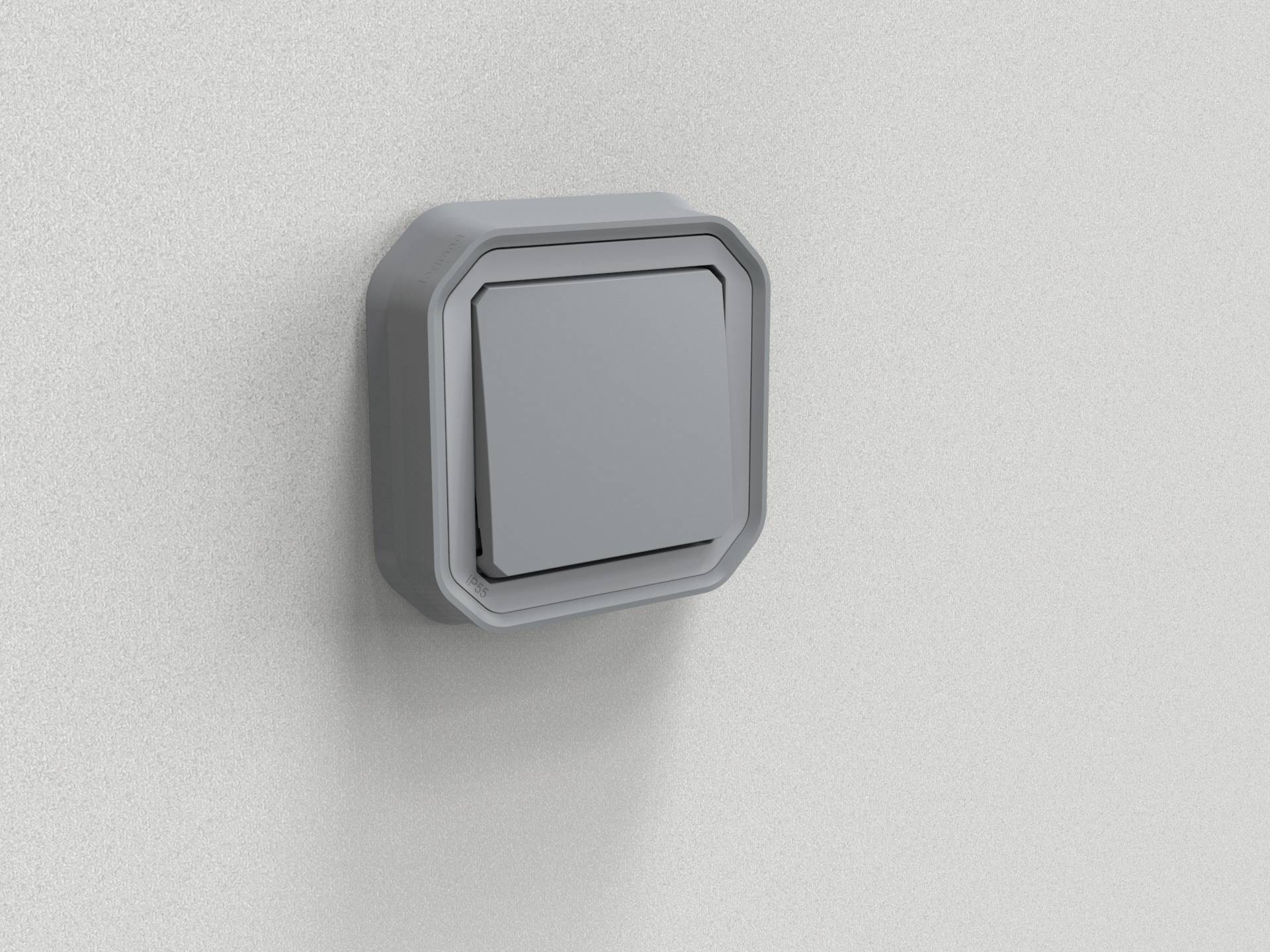 Un interrupteur gris sur un mur blanc.