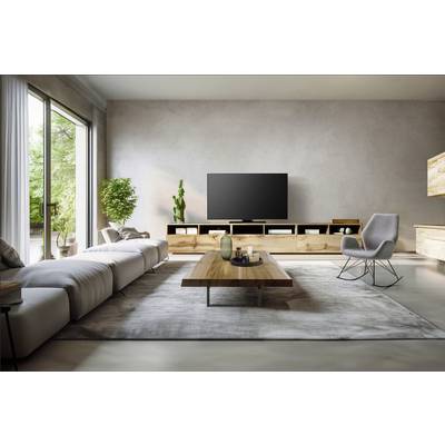 Salon moderne avec un grand canapé, une télévision sur une table en bois, un fauteuil et de grandes fenêtres offrant une vue sur un jardin verdoyant.