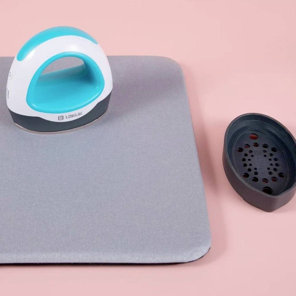 Un défroisseur vapeur avec support et réservoir d'eau sur fond rose. Adapté pour défroisser les tissus sans fer à repasser.