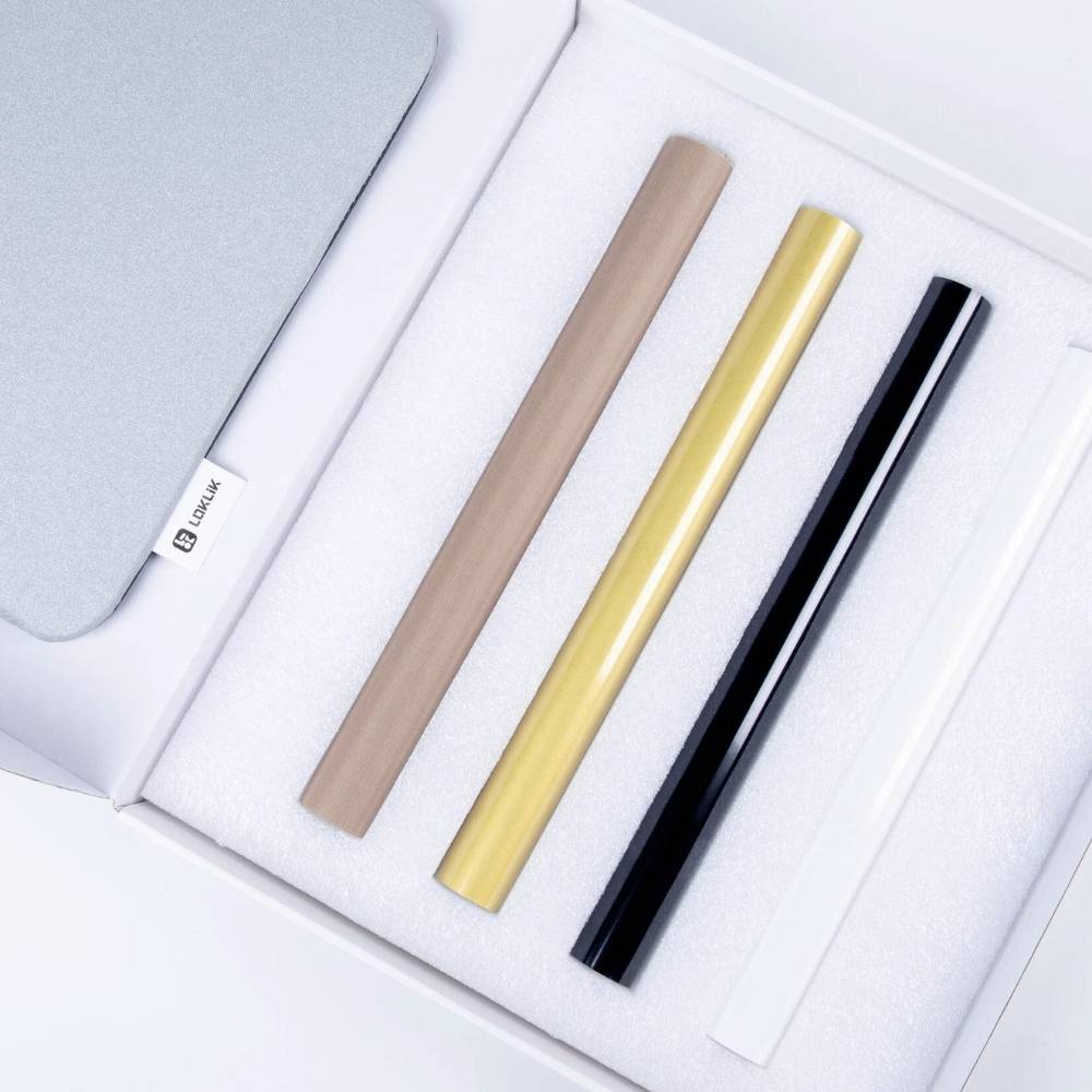 Quatre objets tubulaires côte à côte dans les couleurs marron, jaune, noir et blanc, placés dans une boîte blanche.