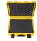 Une valise jaune ouverte, doublée de mousse noire à l'intérieur, adaptée au transport sécurisé d'objets fragiles.