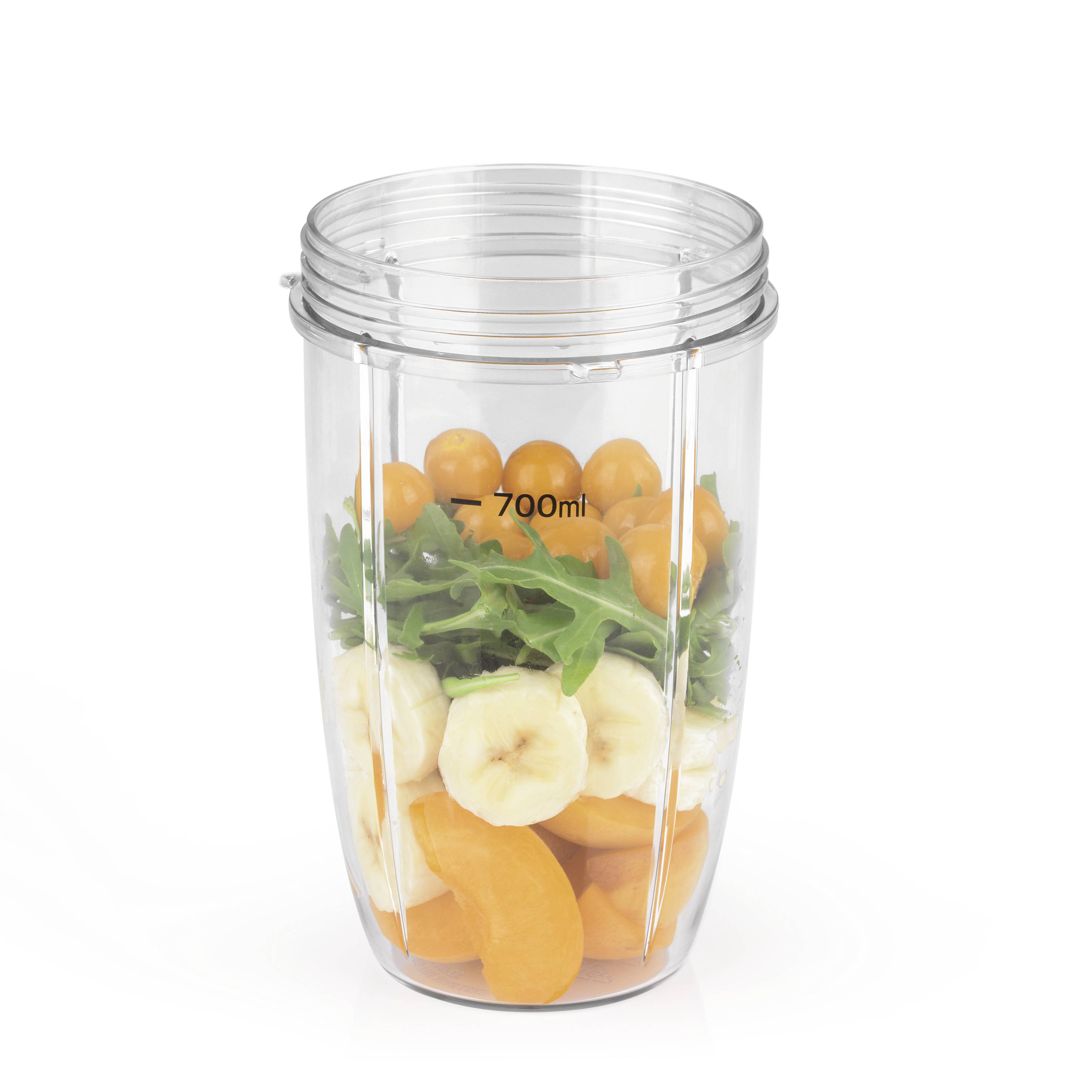 Un récipient de mixeur contenant des tranches de banane, des morceaux d'orange, des tomates et de la roquette, rempli jusqu'à la marque de 700 ml.