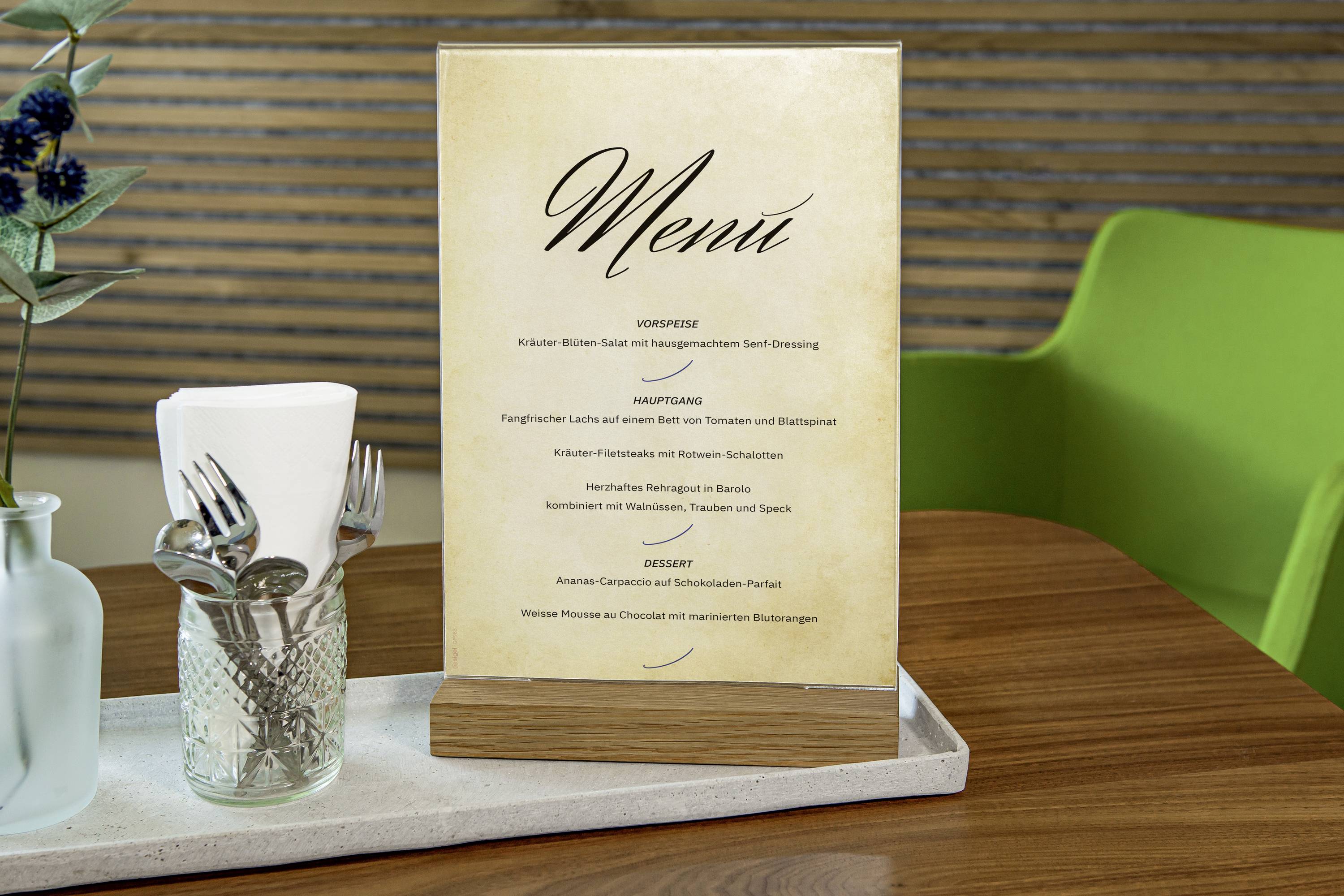 Menu dans un support en bois posé sur une table, comprenant des entrées, des plats principaux et des desserts dans un environnement de restaurant.