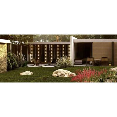 Un jardin moderne avec une pelouse, des buissons décoratifs et des rochers. À l'arrière-plan, une terrasse éclairée avec des meubles en bois et des plantes.