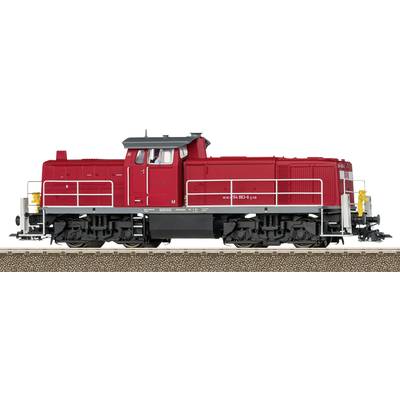 Un modèle rouge d'une locomotive diesel est posé sur une section de voies ferrées. La locomotive présente des structures et des roues détaillées.