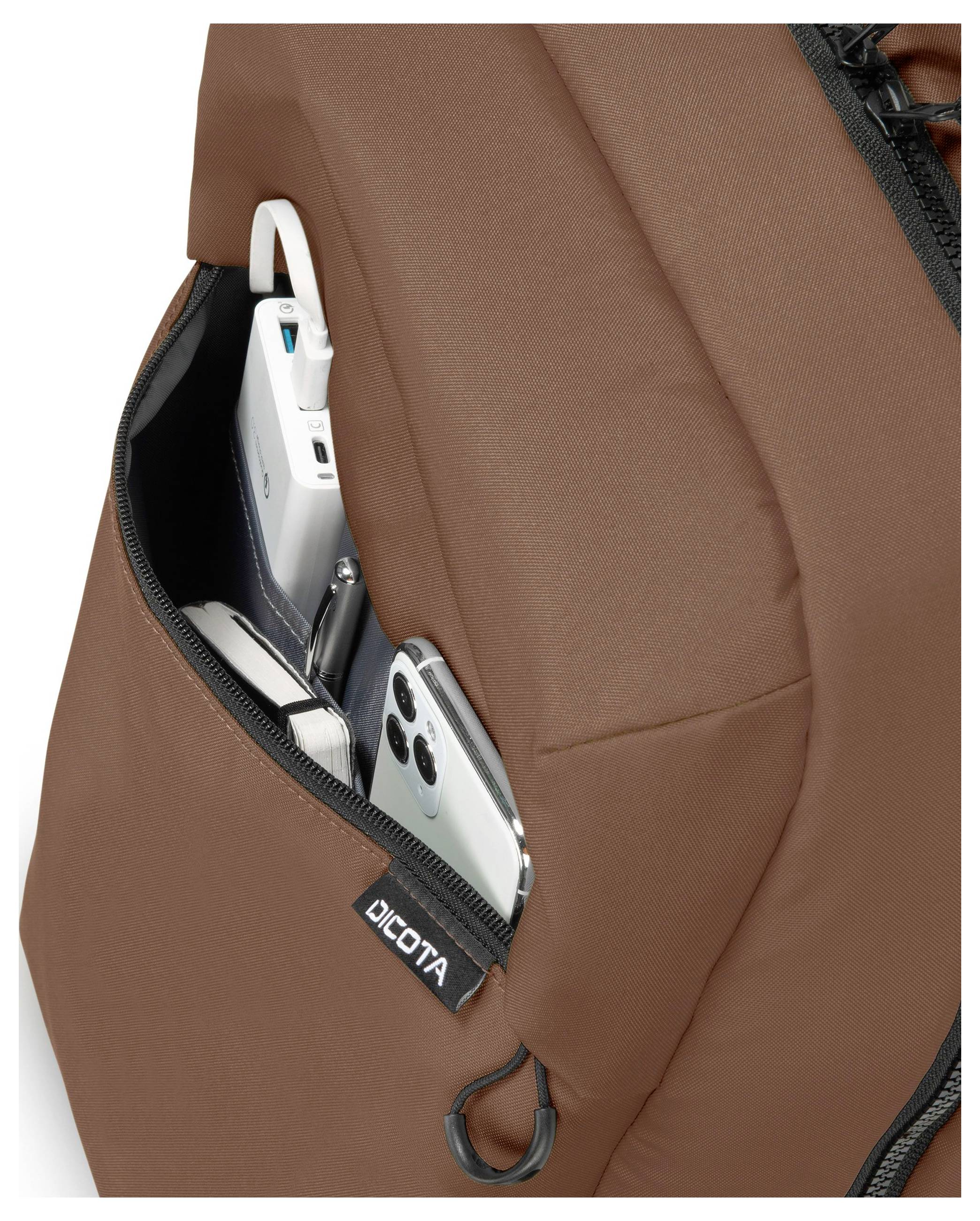 Un sac à dos marron avec une poche latérale, dans laquelle on peut voir un smartphone et un câble de chargement qui dépasse.