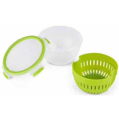 Un bol vert avec un égouttoir et un couvercle transparent sont posés à côté d'un bol blanc sur une surface blanche.