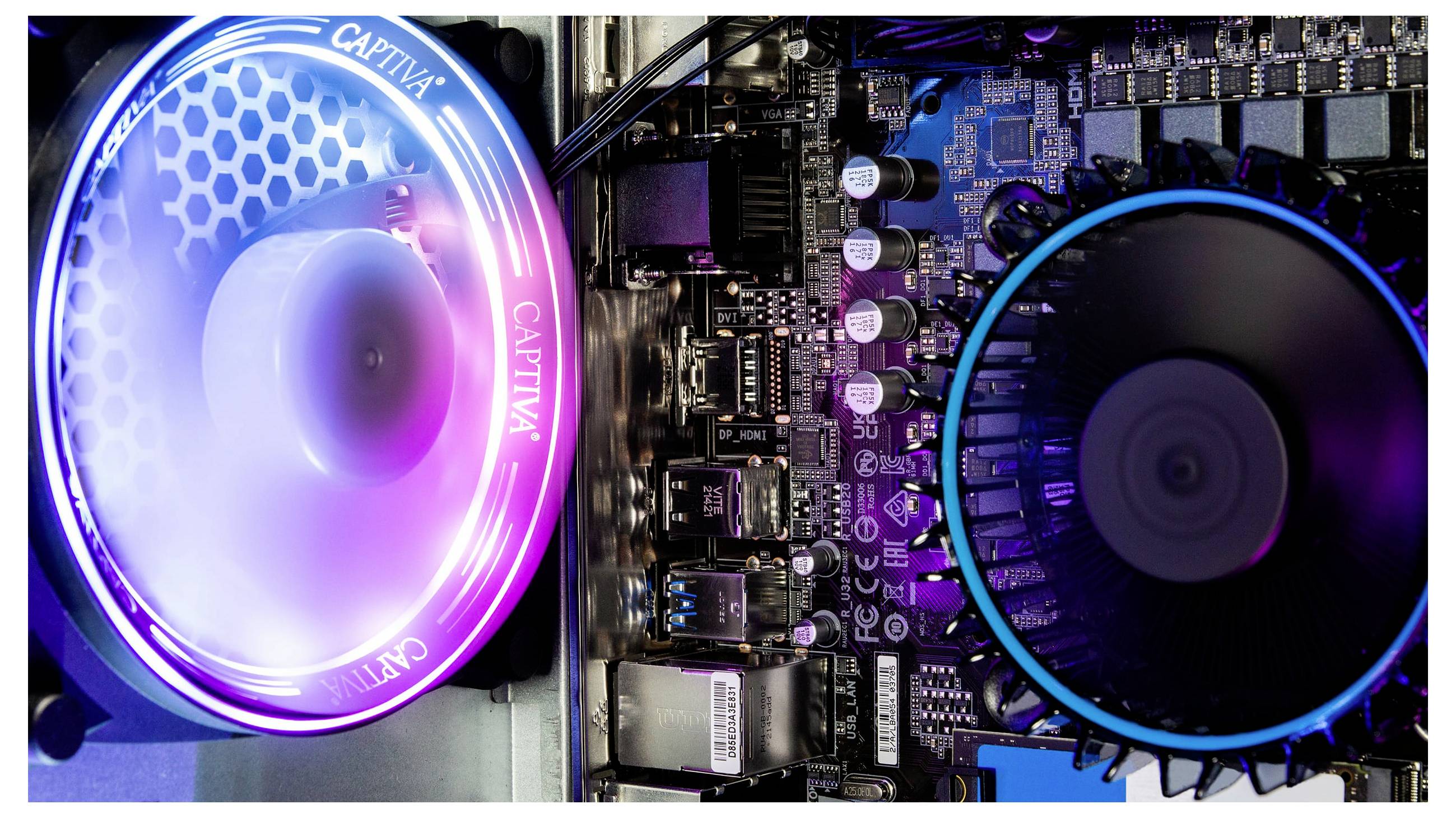 Un intérieur de PC avec deux ventilateurs lumineux en bleu et violet. Carte mère visible avec plusieurs connecteurs et composants électroniques.