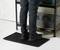 Une personne se tient sur un tapis antidérapant à motif alvéolé devant une étagère contenant des boîtes à outils. Le tapis offre une excellente stabilité grâce à son design en nid d'abeille.