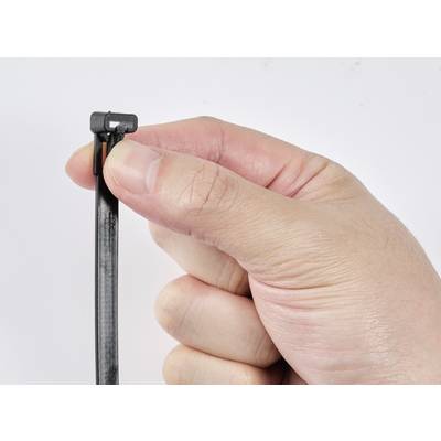 Une main tient un collier de serrage noir, prêt à être resserré. Gros plan sur le doigt près du fermoir.