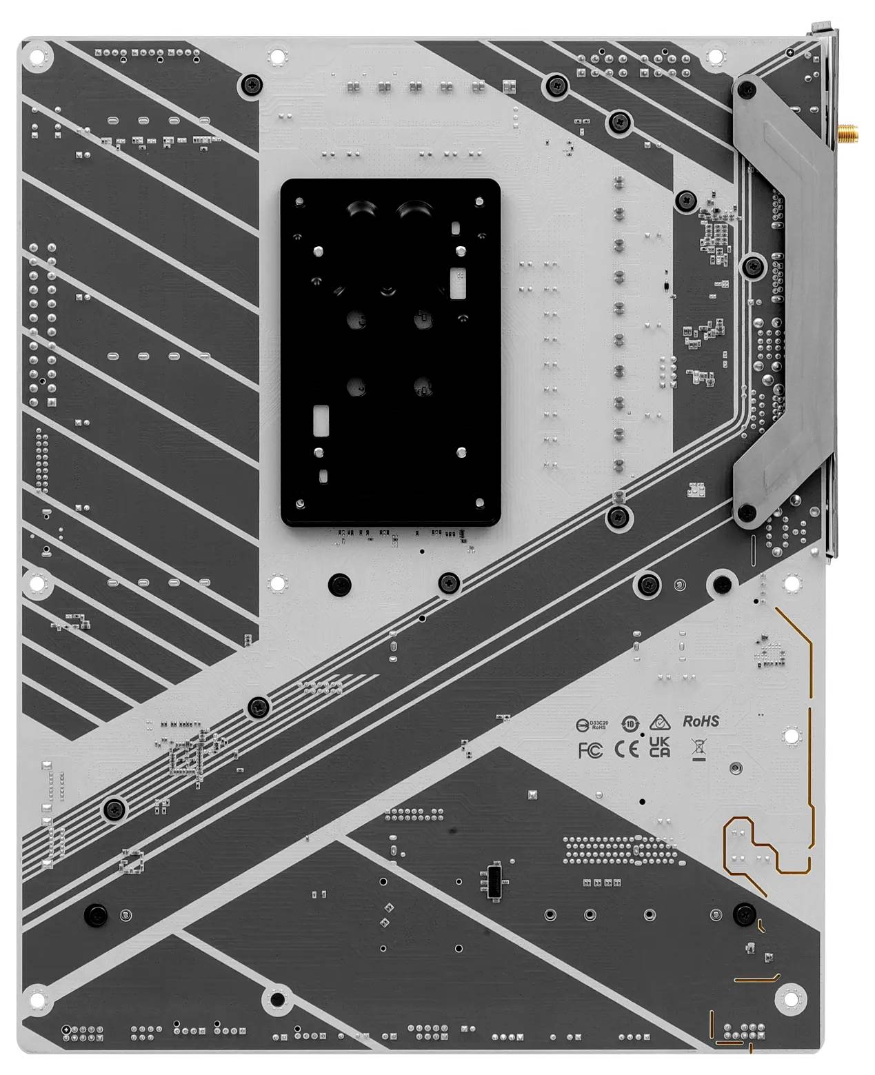 Arrière d'une carte mère d'ordinateur avec des circuits gris et des barrettes de connexion argentées, révélant des détails techniques.