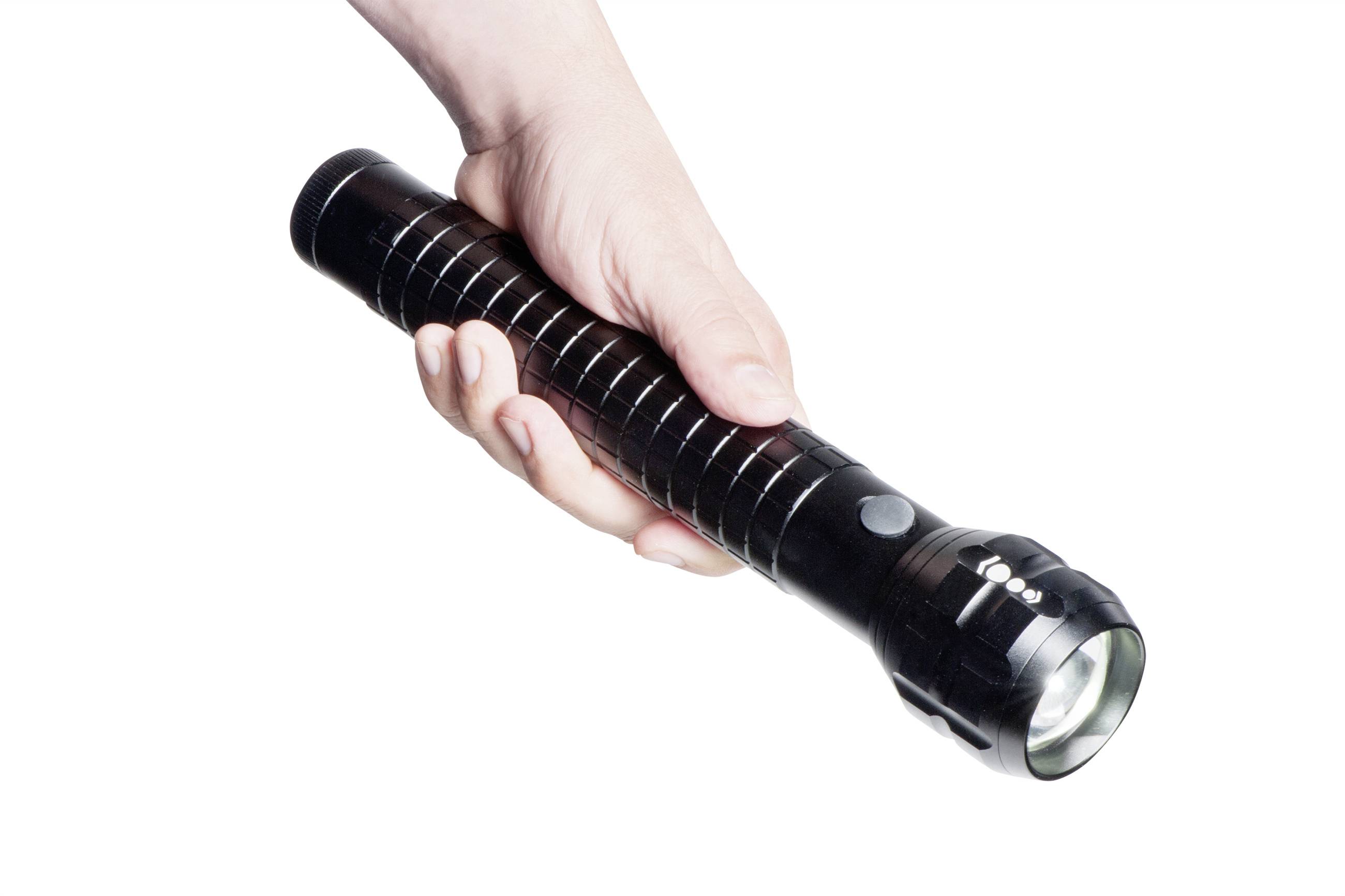 Une main droite tient une lampe de poche noire, allongée, qui est allumée et projette sa lumière vers le bas.