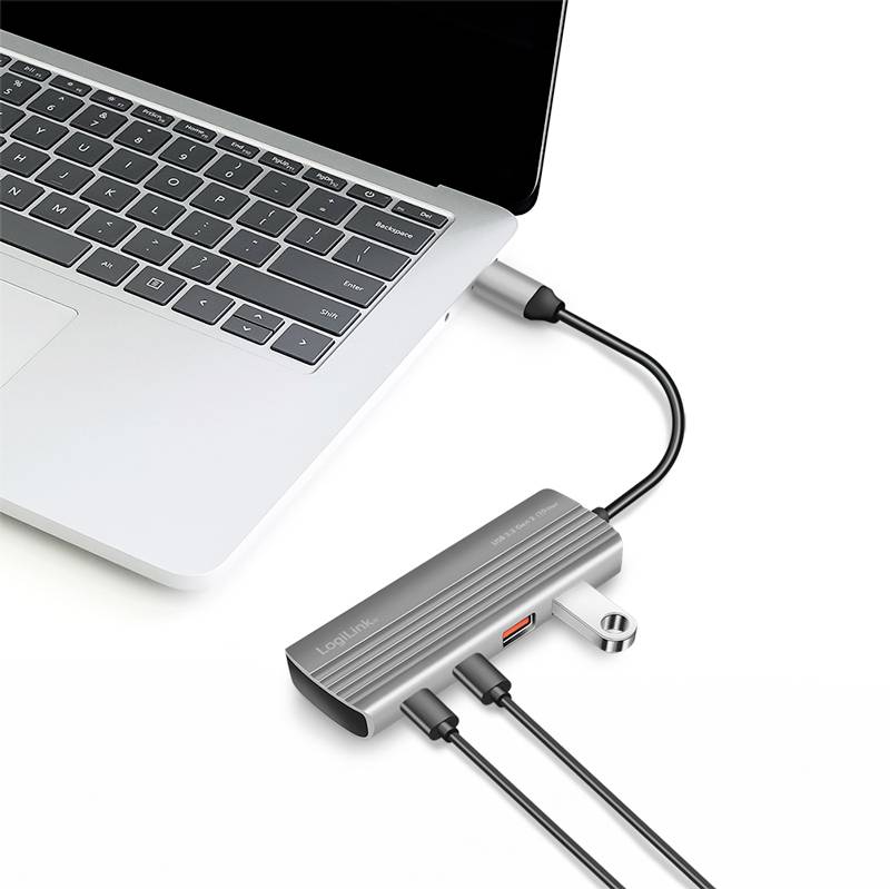 Un ordinateur portable argenté est connecté via un hub USB-C avec plusieurs câbles, comprenant notamment une connexion HDMI et un port USB.