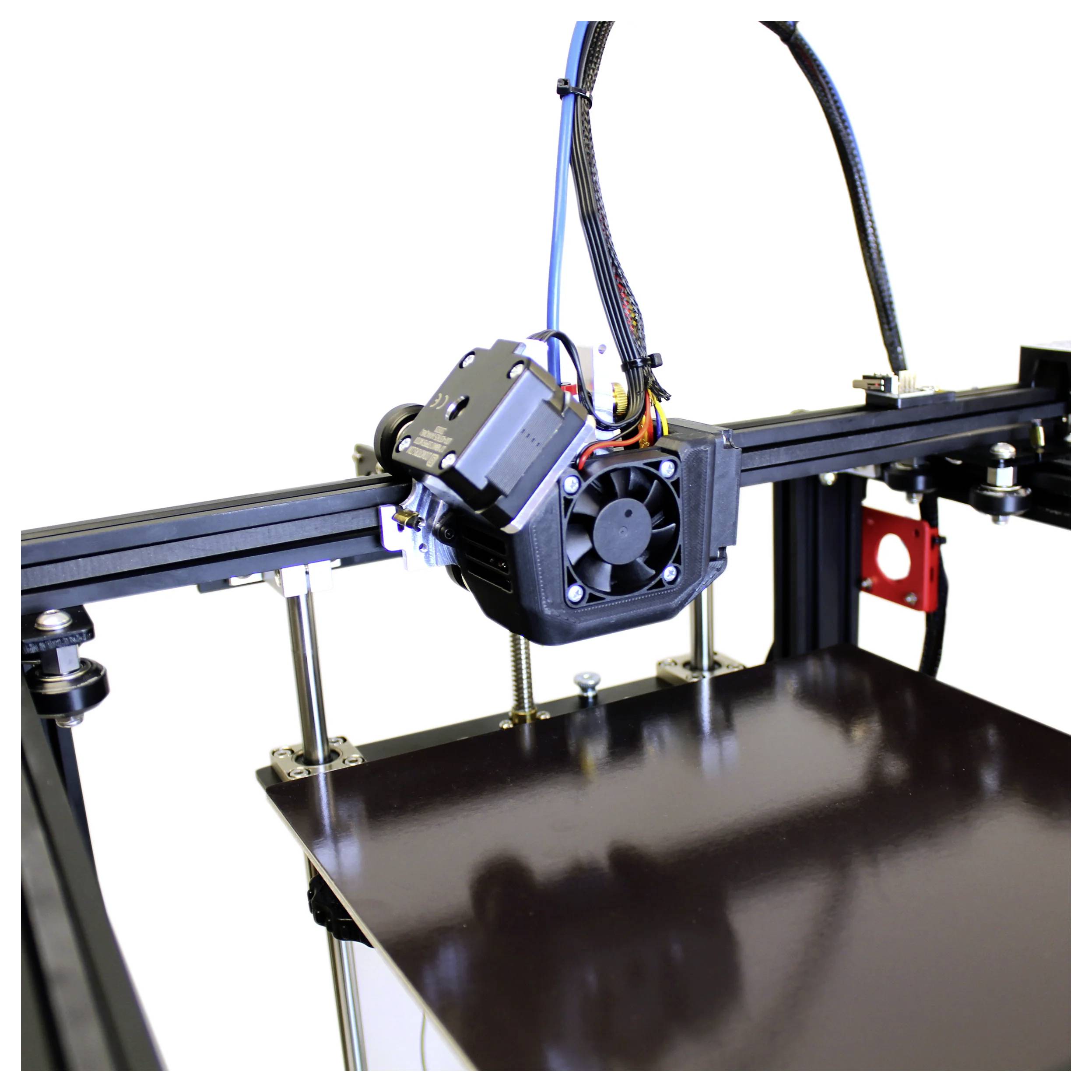 Une imprimante 3D avec une tête d'impression positionnée au-dessus d'un plateau de construction brillant sur un cadre en métal noir.