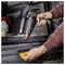 Une personne utilisant un pistolet thermique pour appliquer un film vinyle jaune à la surface d'une voiture à l'intérieur d'un coffre ouvert.