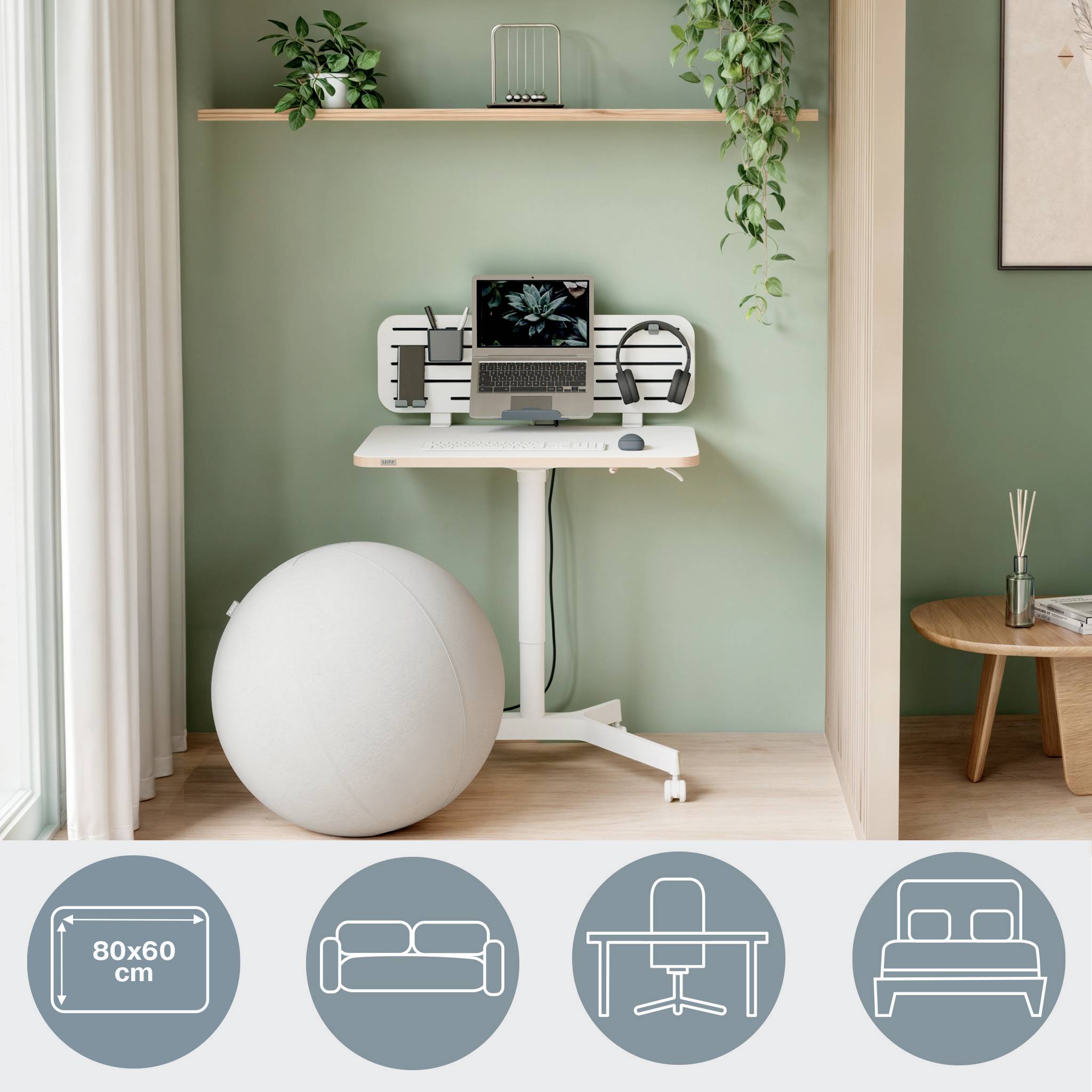 Un bureau à domicile minimaliste avec un fond vert, un bureau debout, un ordinateur portable, des écouteurs, une plante et un ballon de gym.