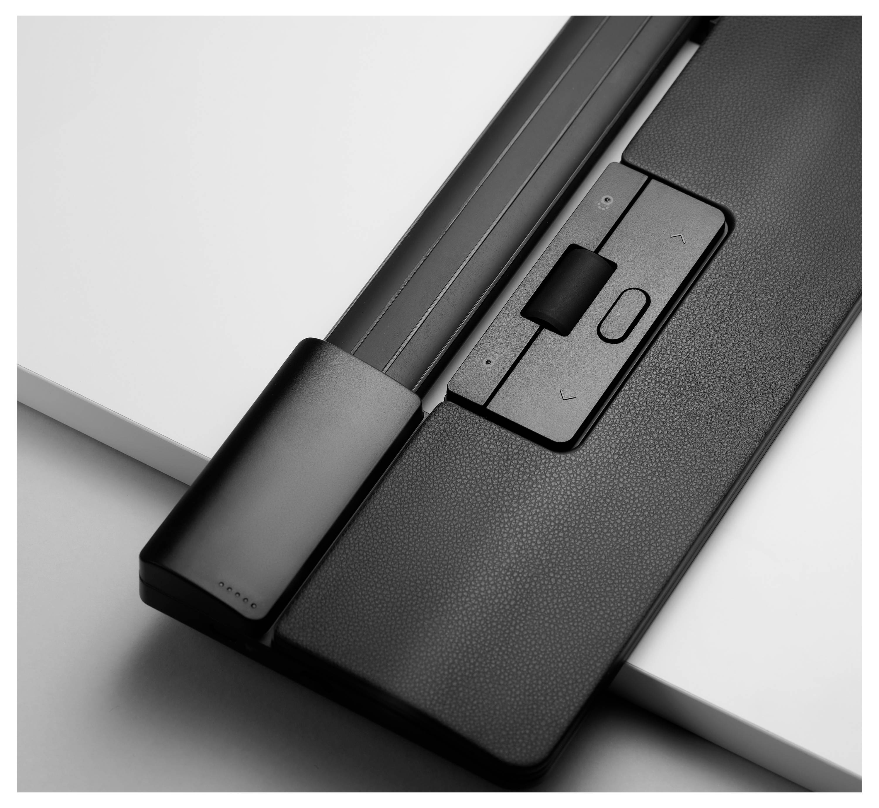 Gros plan en noir et blanc d'un appareil technique avec des touches 'Monter' et 'Descendre' placées sur une surface.