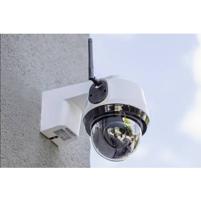 Caméra de sécurité montée sur un mur de bâtiment, surveillant la zone extérieure.