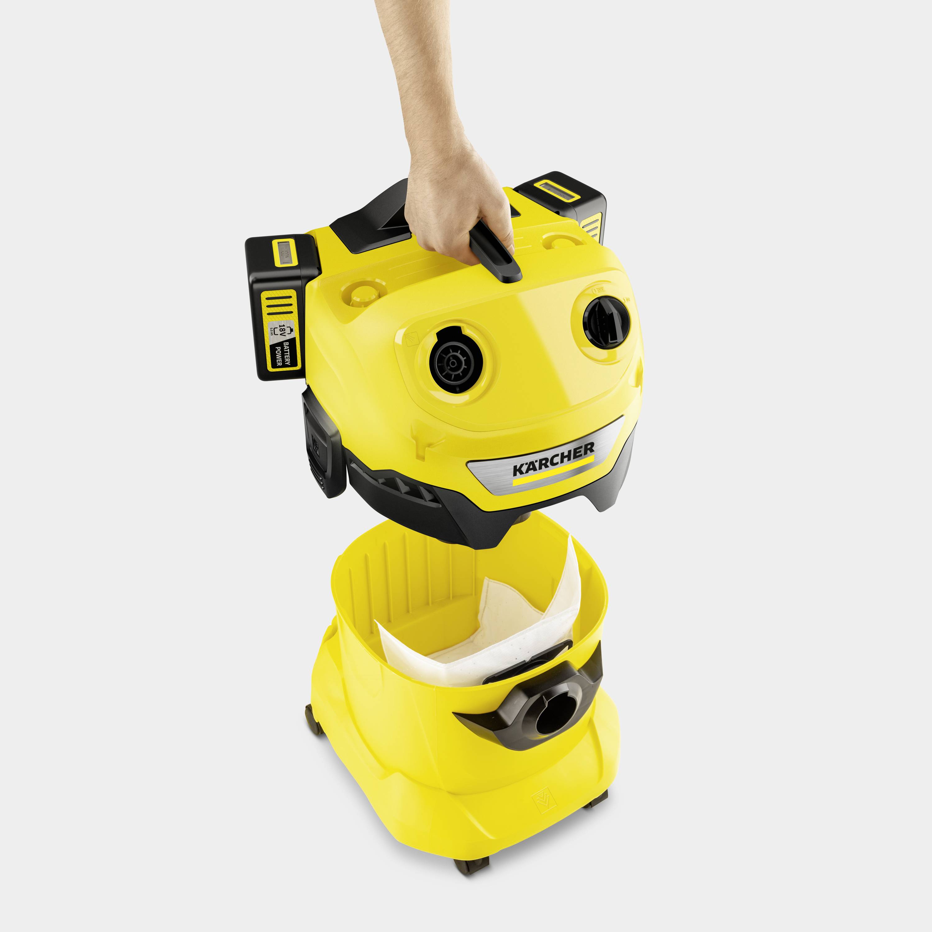 Un aspirateur jaune avec son réservoir ouvert. Une main retire la partie supérieure pour accéder à l'intérieur. Le nom de la marque est visible.