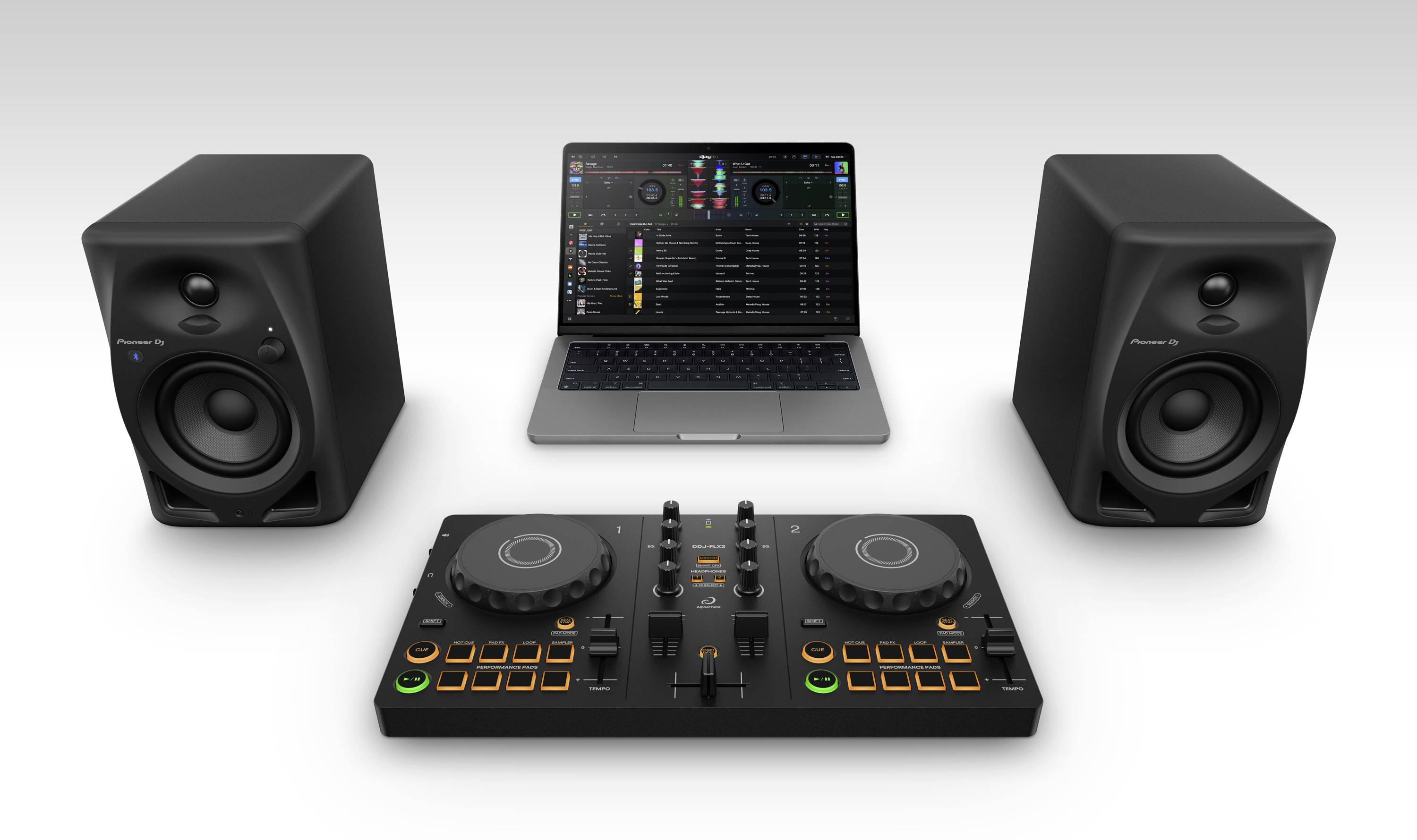 Ordinateur portable ouvert avec un logiciel de DJ à l'écran, devant un contrôleur DJ avec des touches et des potentiomètres, avec un haut-parleur de chaque côté.