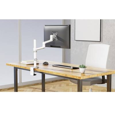 Un bureau moderne avec un bras de support pour moniteur sur lequel un écran est monté. À côté se trouvent un clavier, une souris et une petite plante.